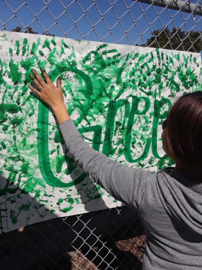 A freshmen student proudly becomes a part of the Green Hand crew. 